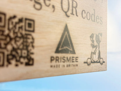 Wooden box with laser-engraved QR codes and Prisme brand logo on a light blue background