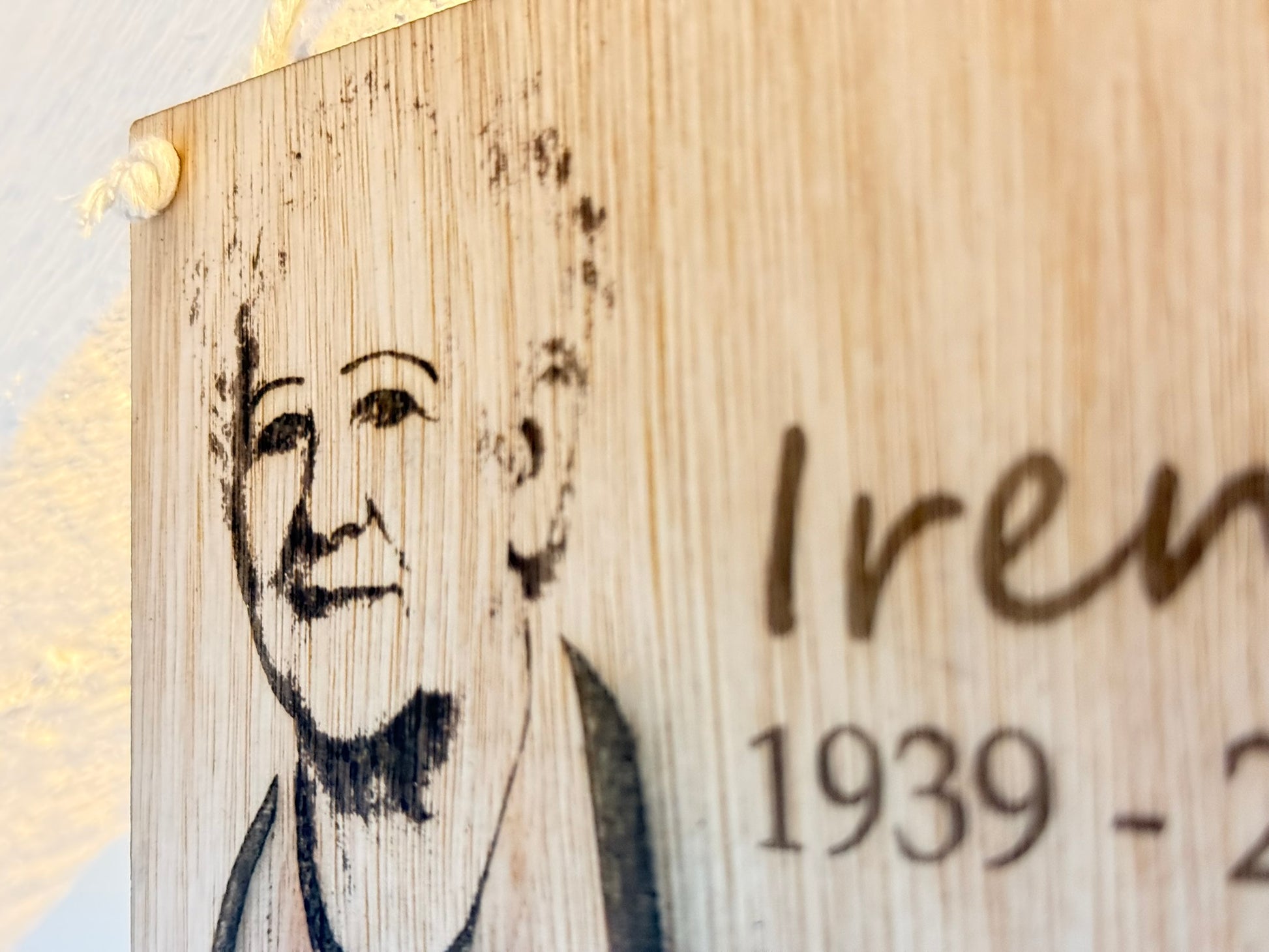 Wooden plaque with engraved portrait and text on a light background