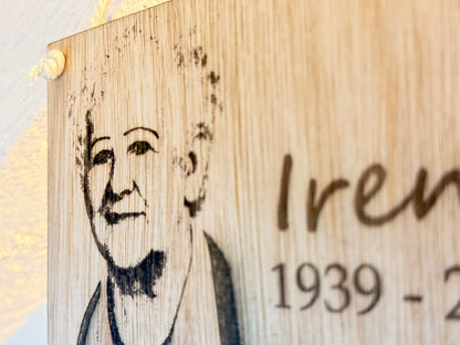 Wooden plaque with engraved portrait and text on a light background