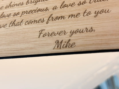 Wooden plaque with engraved message 'Forever yours, Mike' on a wooden surface.