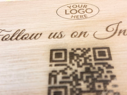 Wooden surface with engraved text and QR code, placeholder for 'Your Logo Here'.